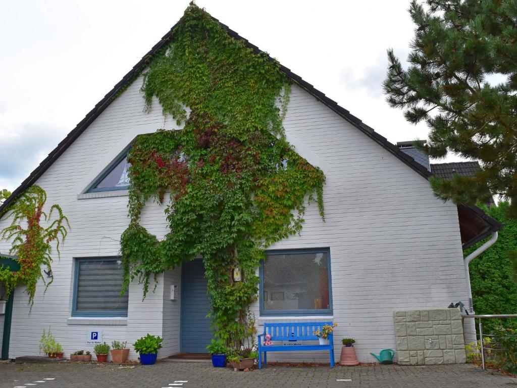 a house with ivy growing on the side of it at Apartment, guest in Güster