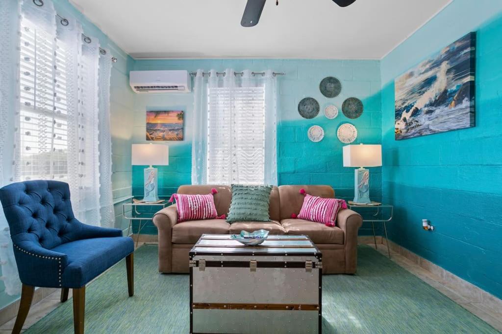 ein Wohnzimmer mit einem Sofa und einer blauen Wand in der Unterkunft Mermaids Grotto WATERFRONT 1BR Apt with Bay View in Tampa