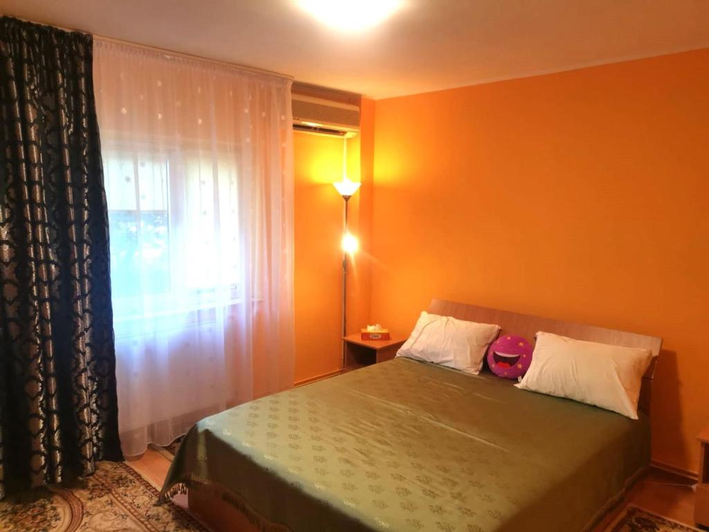 een slaapkamer met een groen bed en een raam bij Central Apartment Bucharest Mall in Vitan