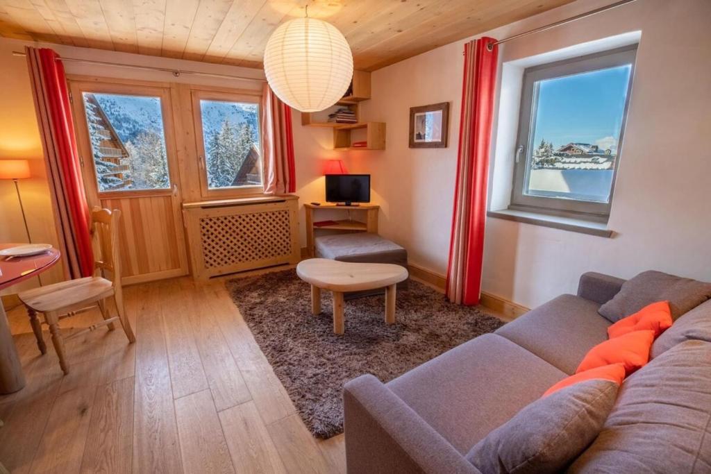 a living room with a couch and a table at Chantemerle 6 in Méribel