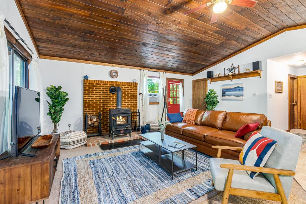 - un salon avec un canapé et une cheminée dans l'établissement Hot Tub, Fire Pit, Screened Porch at Secluded Cabin, à Great Cacapon