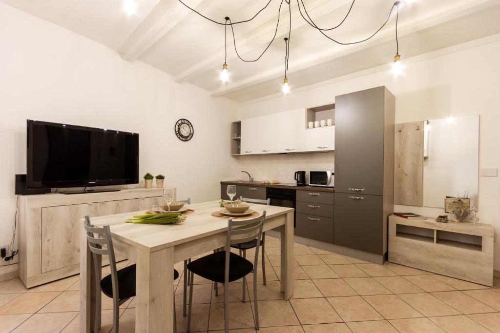 a kitchen with a table with chairs and a tv at Suite Garibaldi - Smart Holiday in Mantova