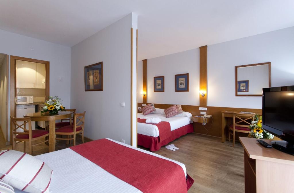 a hotel room with two beds and a table at Muralto Madrid Princesa in Madrid