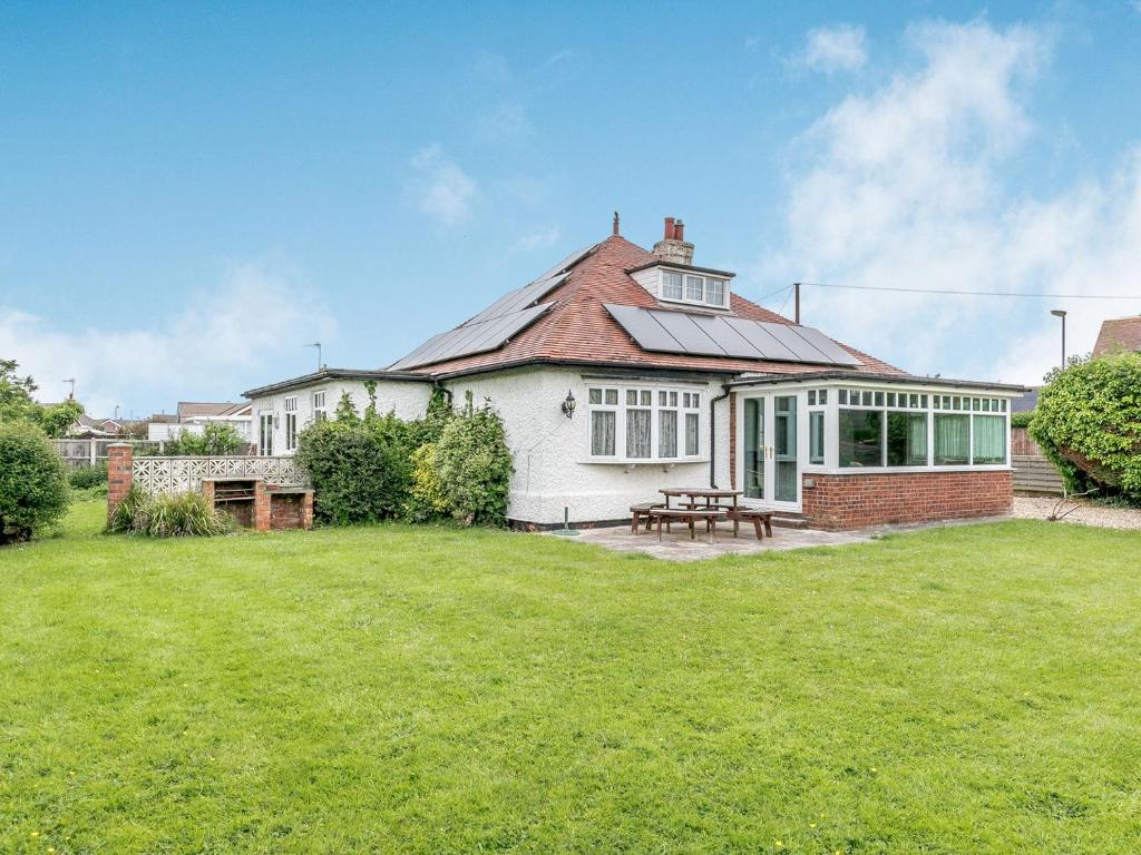 a white house with a picnic table in a yard at Summer House in Sutton on Sea