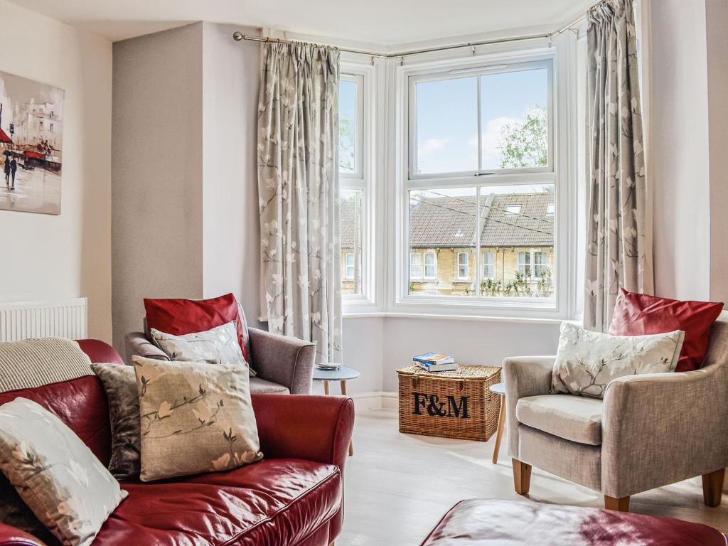 un soggiorno con divano rosso e finestra di Flat 3 Avon Villa a Bradford on Avon