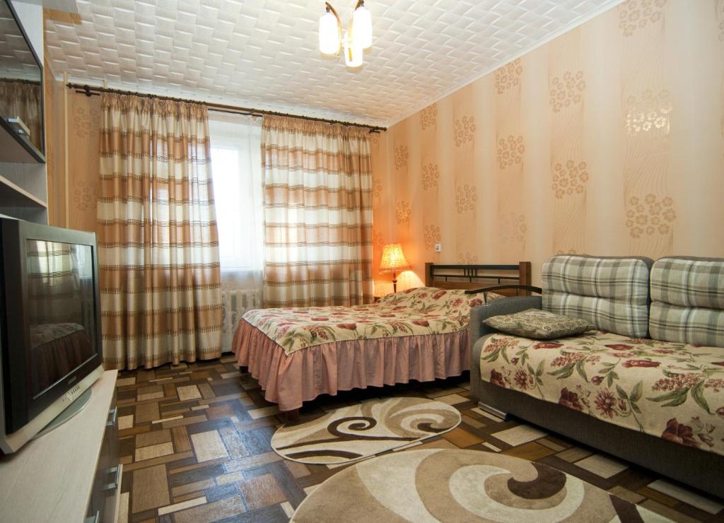 ヤロスラヴリにあるUyut Apartments Chekhovaのベッド2台とテレビが備わるホテルルームです。