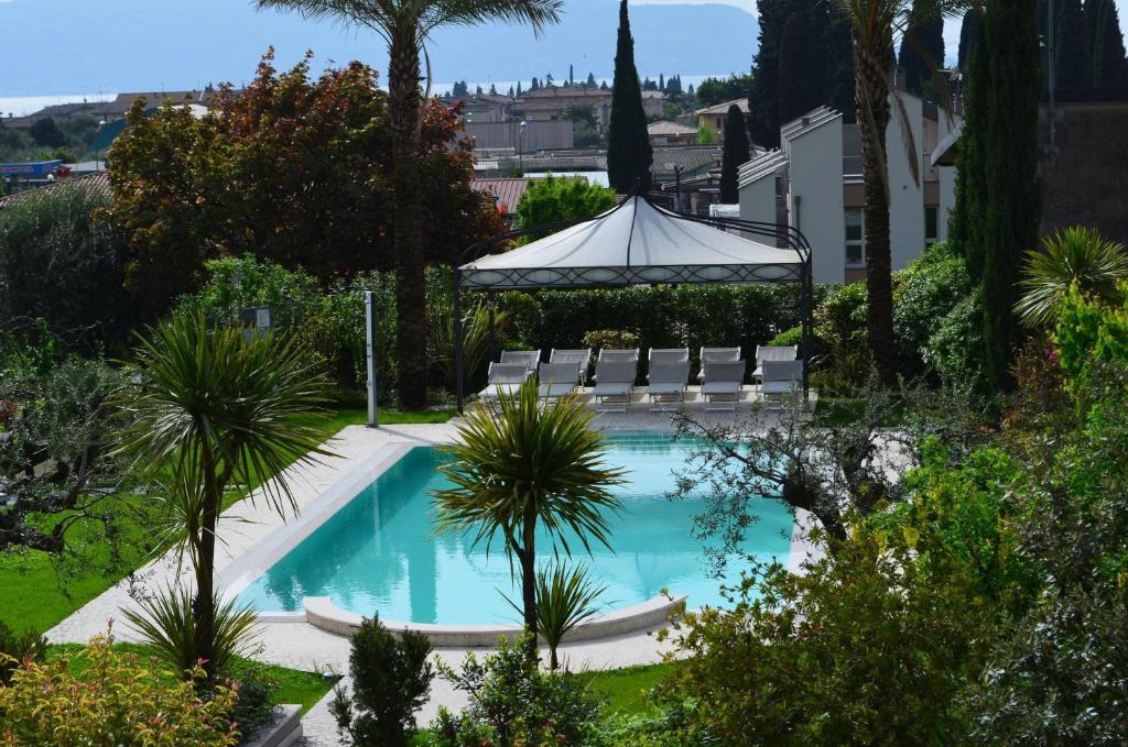 a swimming pool with a gazebo and palm trees at Casa dei Limoni in Toscolano Maderno