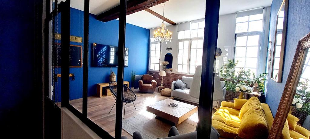 sala de estar con paredes azules y sofá amarillo en LA ROCHELAISE : Appartement calme & somptueux dans l'hyper centre. en La Rochelle