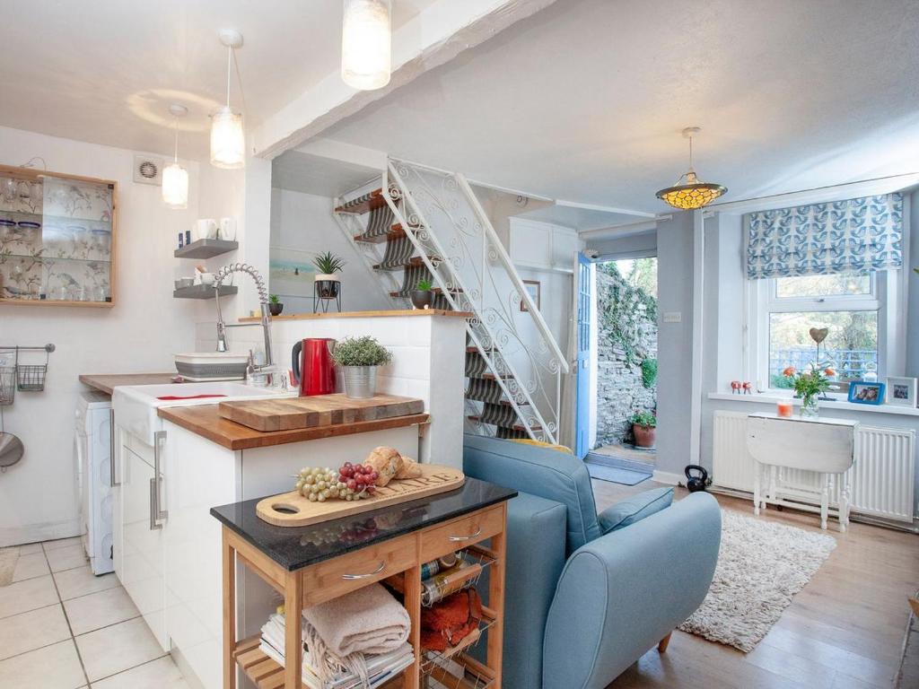 eine Küche und ein Wohnzimmer mit einer Wendeltreppe in der Unterkunft Bird Box in Brixham
