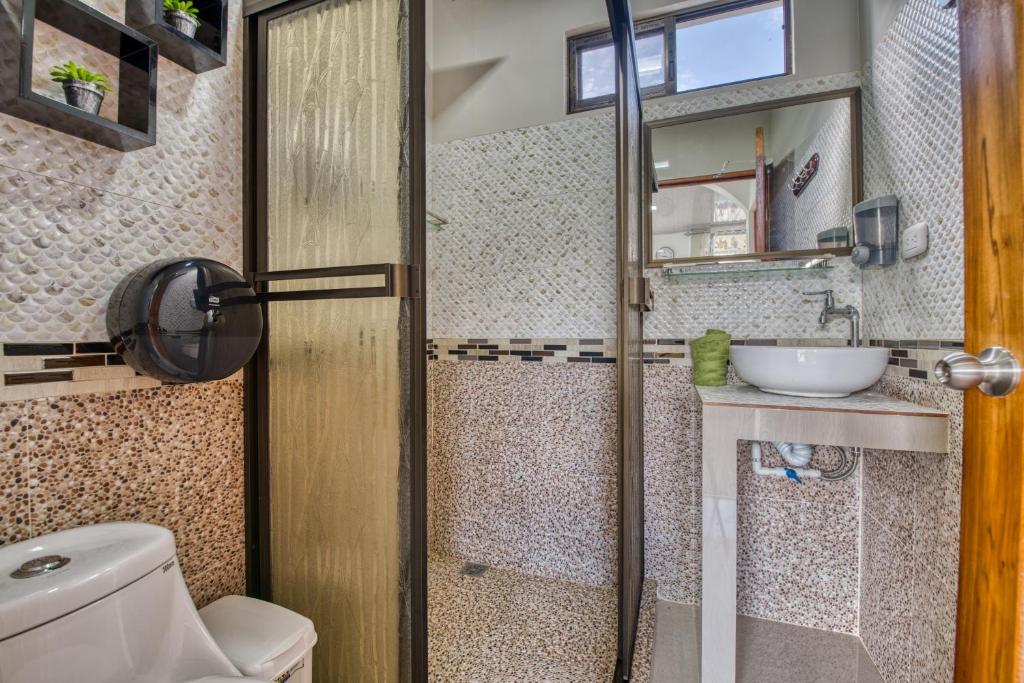 a bathroom with a toilet and a sink at Oso Perezoso Pool Villa in Puerto Viejo