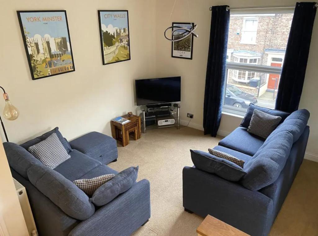 - un salon avec deux canapés et une télévision à écran plat dans l'établissement Park Crescent apartment, à York