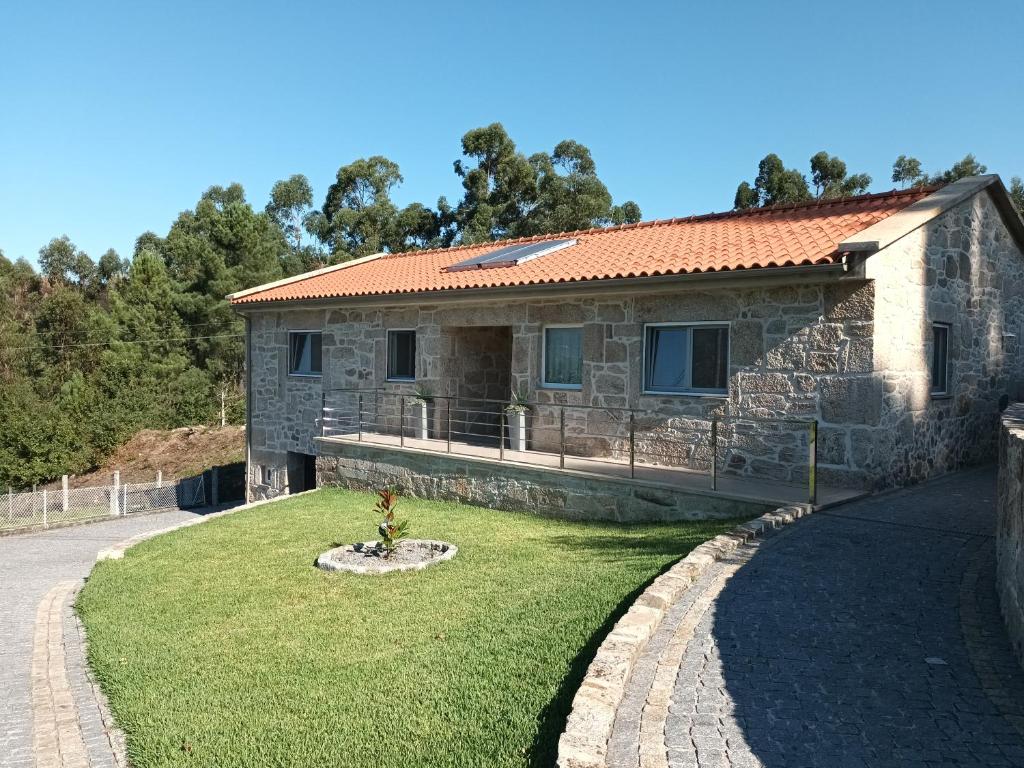 蓬蒂達巴爾卡的住宿－Casa da rosinha - Minho, Portugal，一座石头房子,前面有雕像