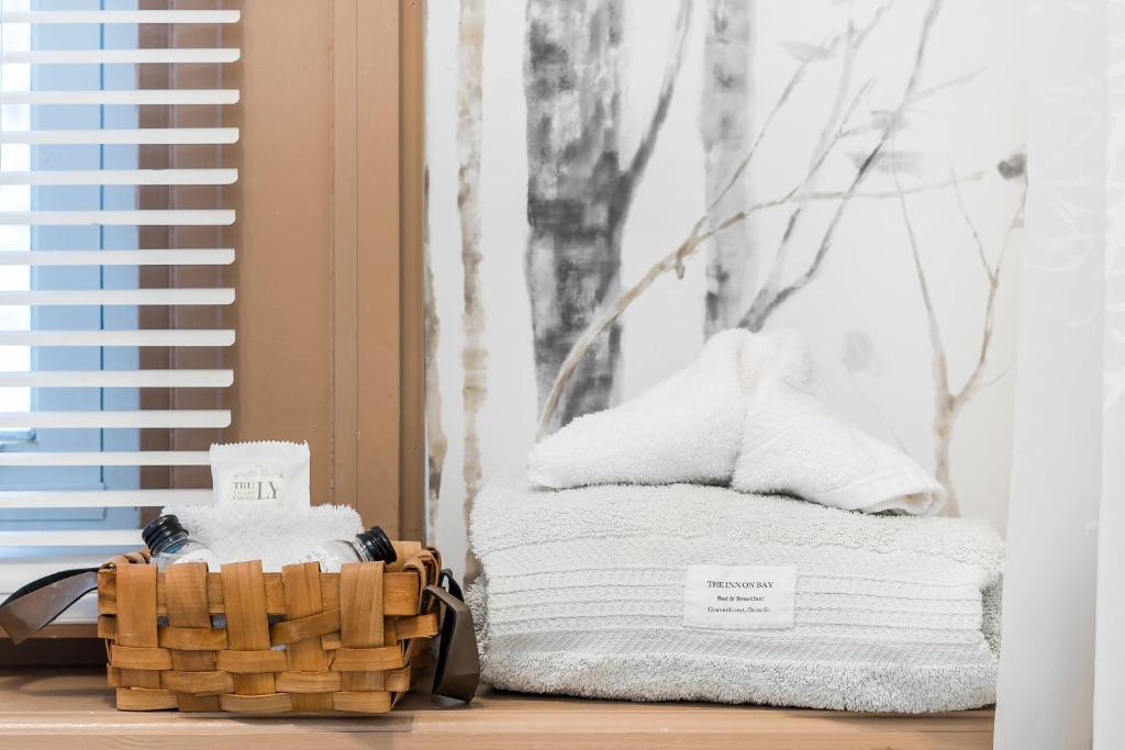 a stack of towels in a room with a window at The Inn on Bay in Gravenhurst