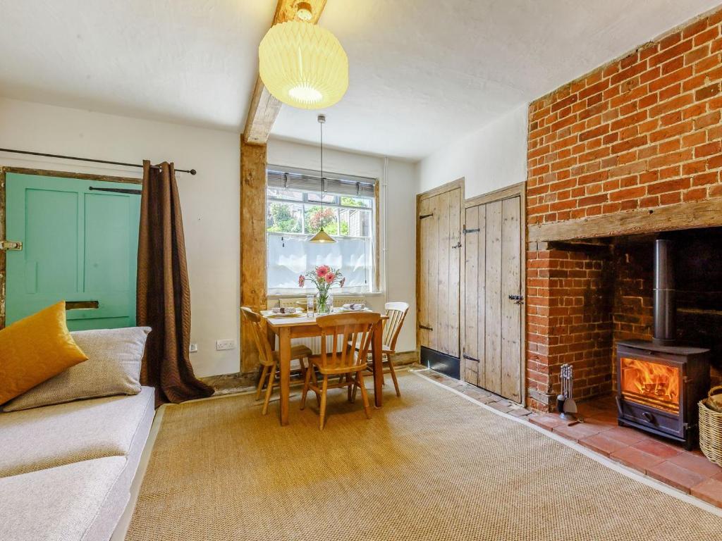 a living room with a table and a brick fireplace at Angel Lane in Woodbridge