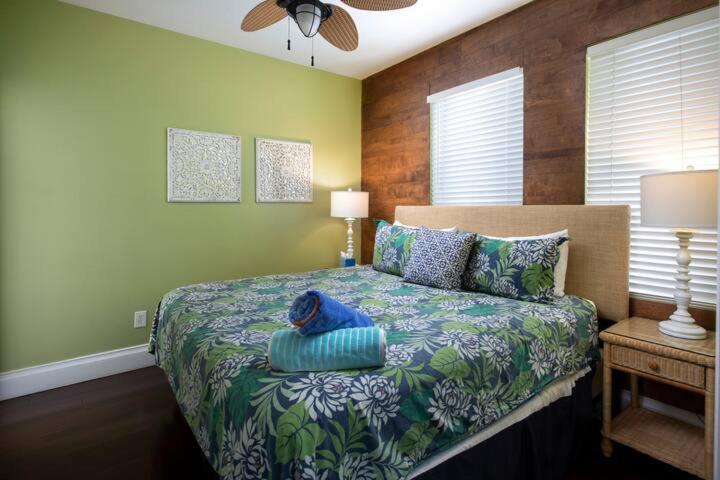 a bedroom with a bed with a blue pillow on it at Two Duval Street Suites w pool in Key West