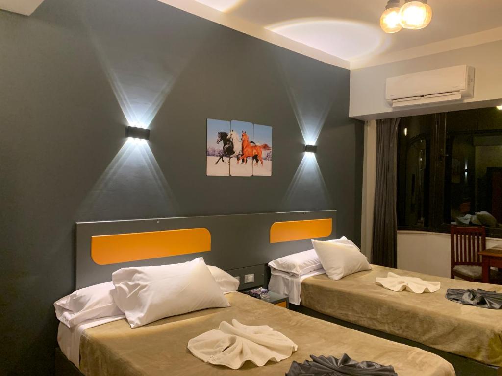 um quarto com duas camas num quarto em Royal Hotel em Qinā