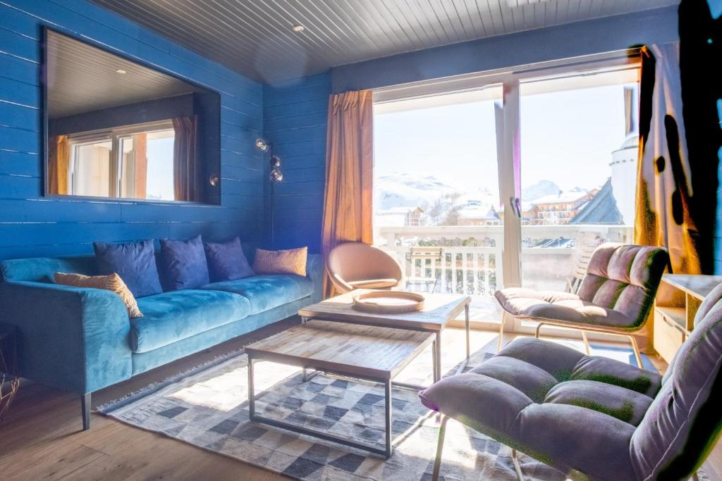 a blue living room with a couch and a table at Beautiful flat in L'Alpe d'Huez heart at the foot of the slopes - Welkeys in LʼHuez