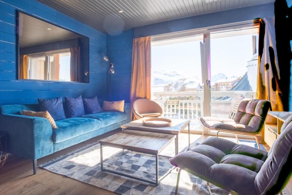 un salon bleu avec un canapé et une table dans l'établissement Appartement Sierra - Welkeys, à Huez