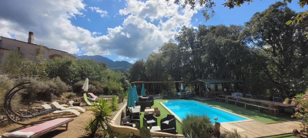 una piscina en un patio con sillas y árboles en Gites San Austinu, en Petreto-Bicchisano