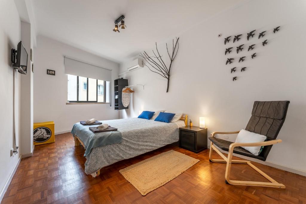 a bedroom with a bed and a chair at Bordallo's Lodge in Caldas da Rainha