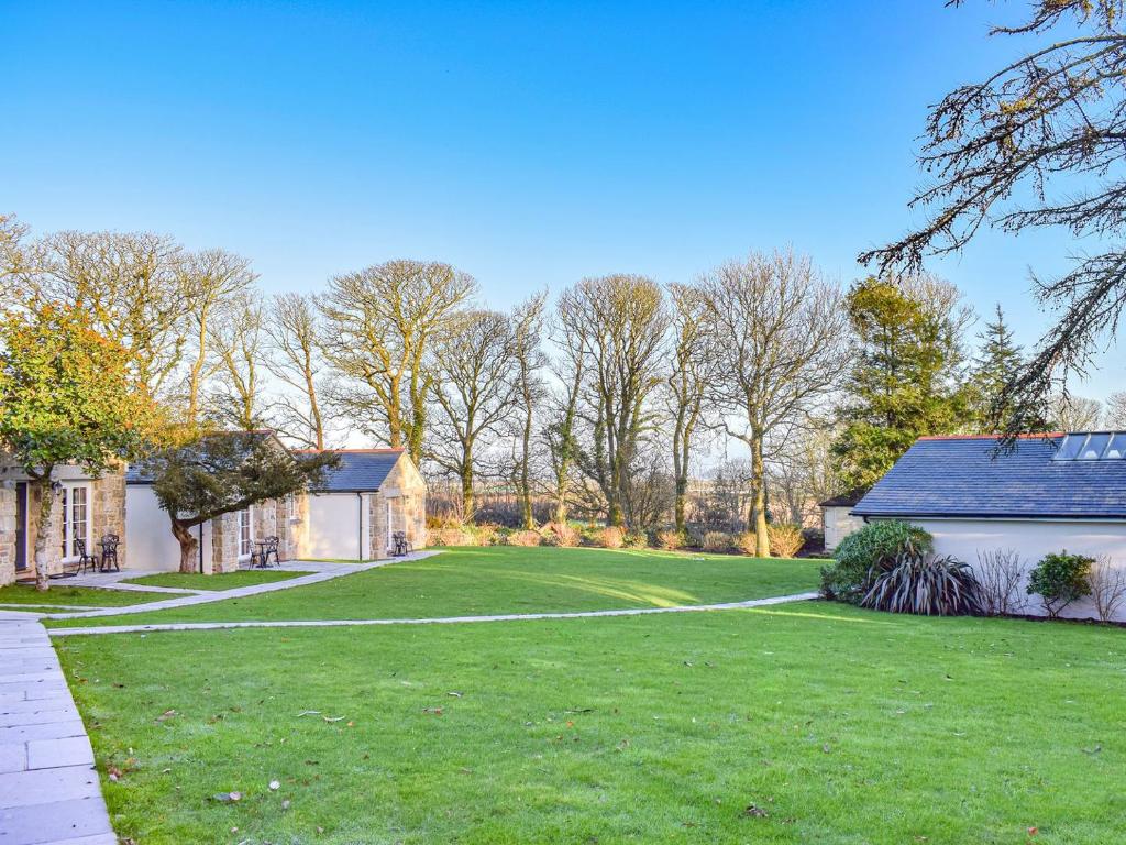a large yard with a house and a lawn at Camelia Cottage-uk37205 in Sancreed