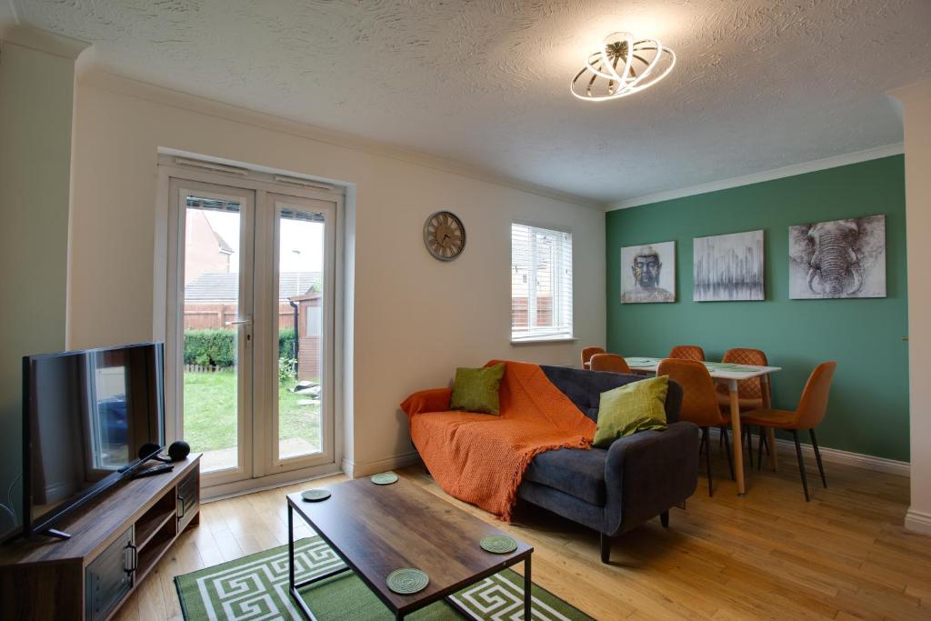 uma sala de estar com um sofá e uma mesa em ST AUSTELL - Spacious Home, High Speed Wi-Fi, Free Parking, Garden em Swindon