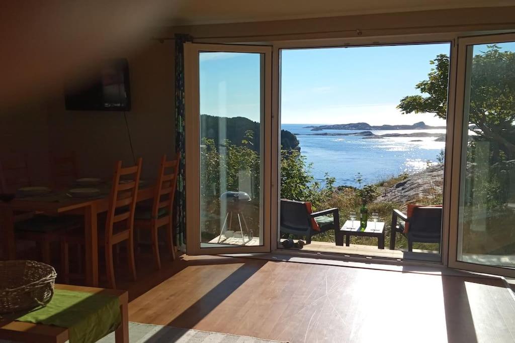 a view of the ocean from a room with sliding glass doors at Apartment , Øygarden, Bergen in Torsteinsvik
