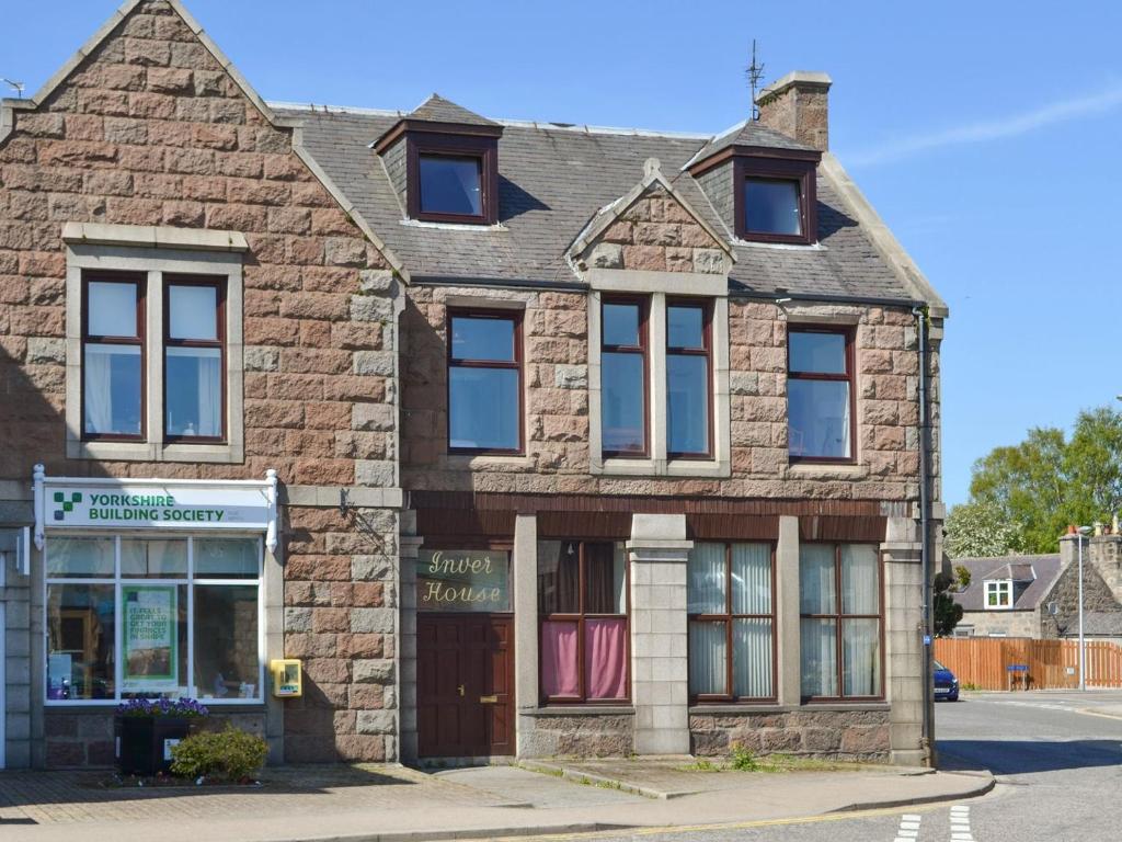 an old brick building on the corner of a street at Inver House Apartment in Inverurie