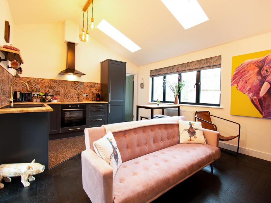sala de estar con sofá y cocina en Diesels Desirable Den - Uk36786, en Sutton Valence