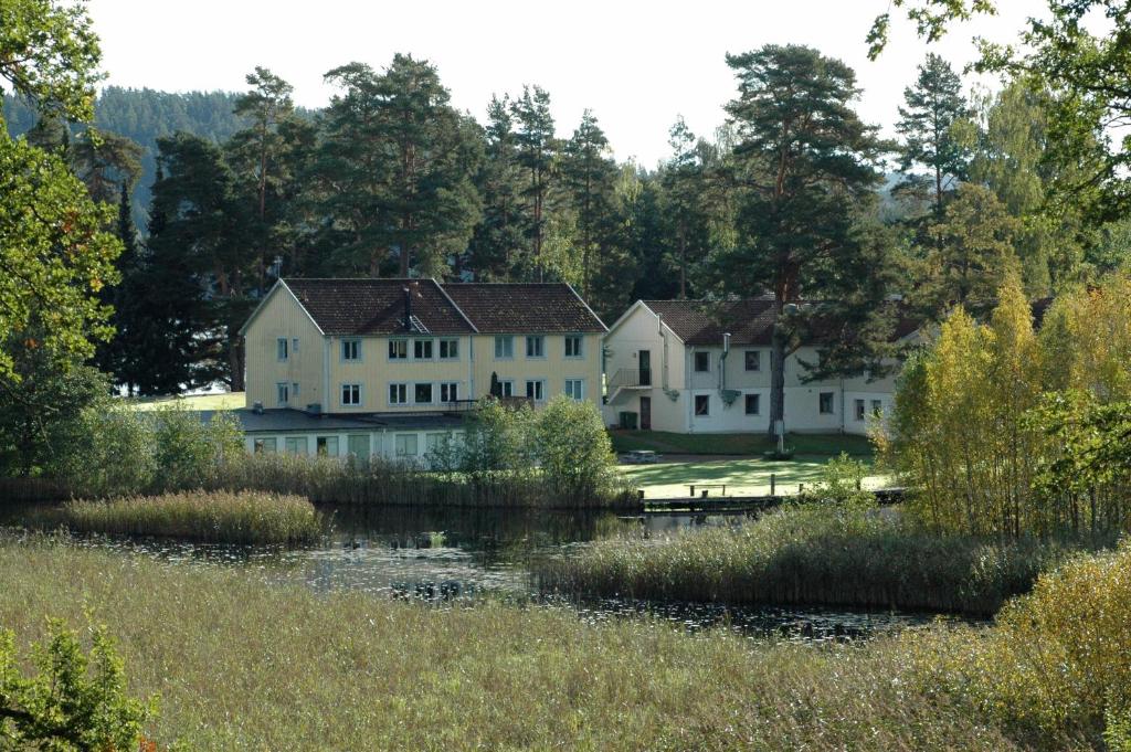 a row of white houses next to a river at Solviken Tranås Hostel in Tranås