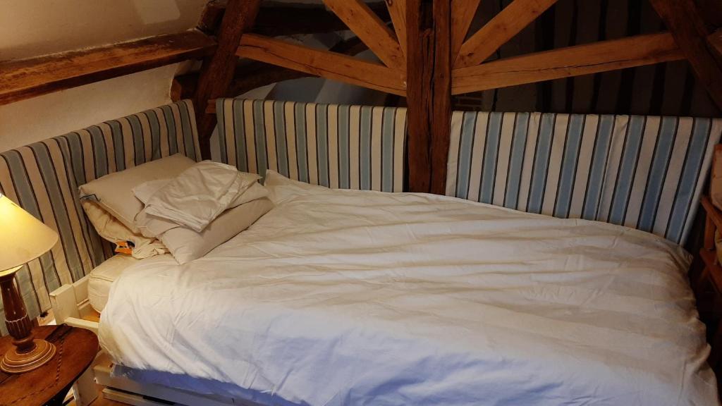 a large white bed in a room with wooden beams at Le Parc aux Oiseaux in Le Mesnil-Simon