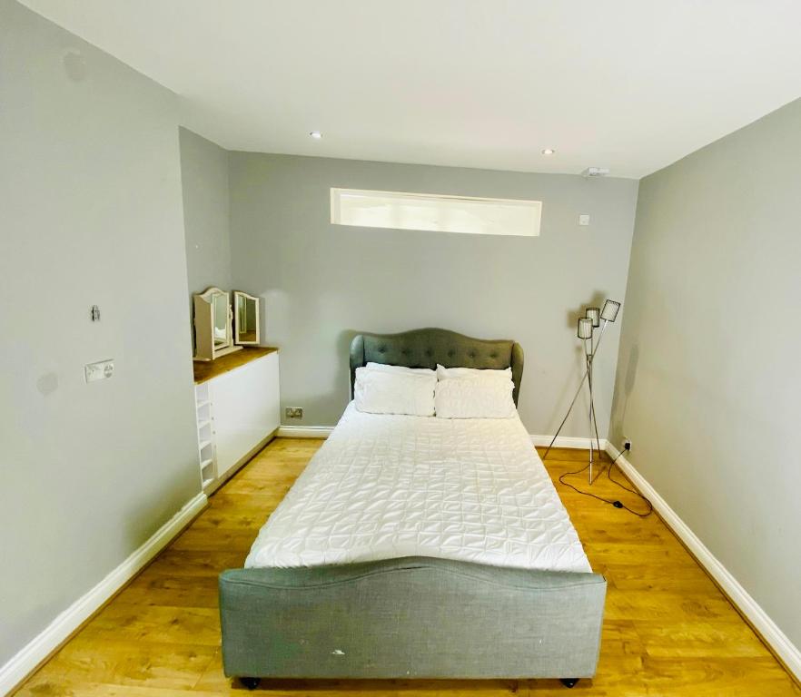 Large king-size bedroom with modern fitted kitchen in Greater London tesisinde bir odada yatak veya yataklar