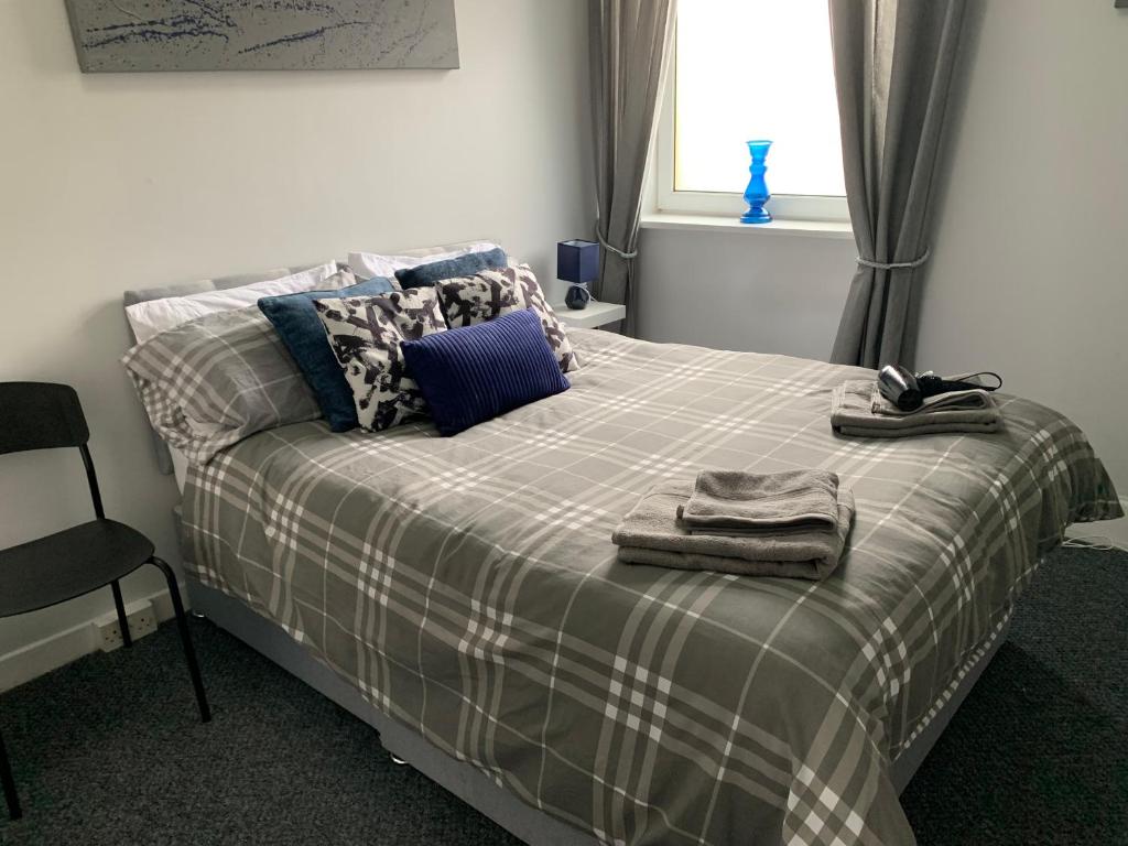 a bedroom with a bed with a plaid blanket at Nelson st ALVA in Largs