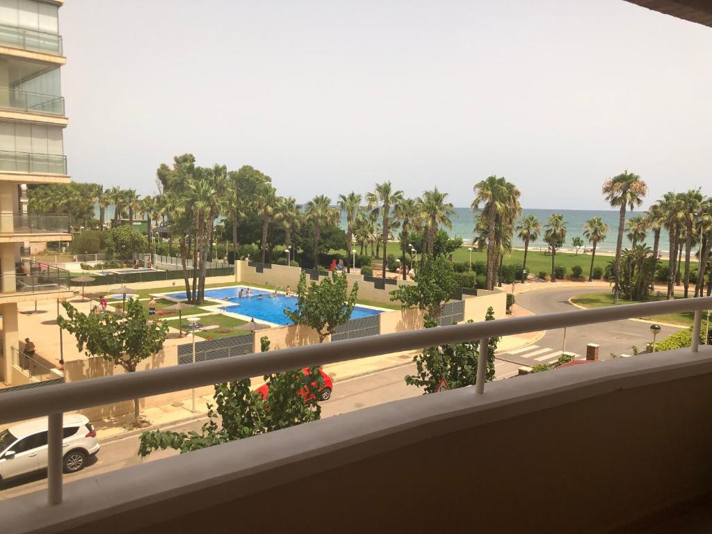 d'un balcon avec vue sur la piscine et les palmiers. dans l'établissement Acapulco III Marina DOR Beach front - Sea views, à Oropesa del Mar