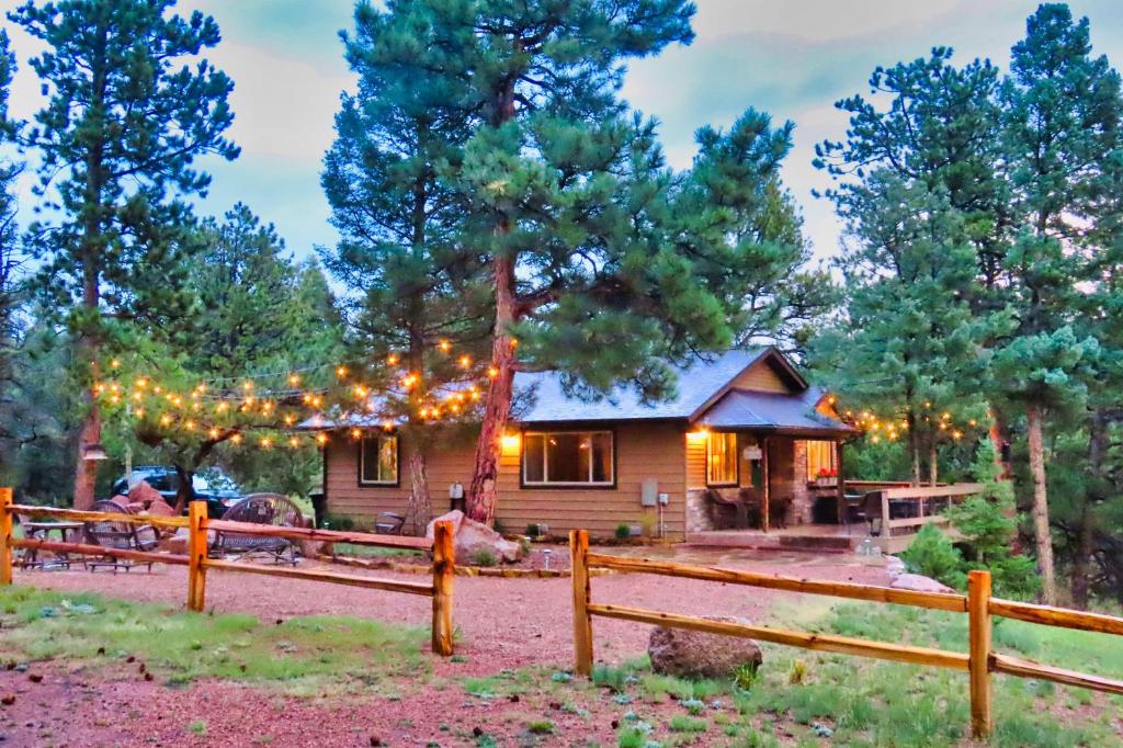 a cabin in the woods with a fence at Pine Ridge - Memories are made here! in Florissant