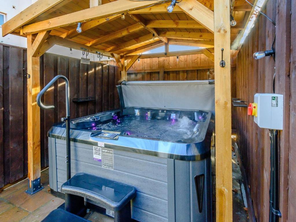 a hot tub in a building with a wooden ceiling at Hidden Winds Cottage in Guisborough