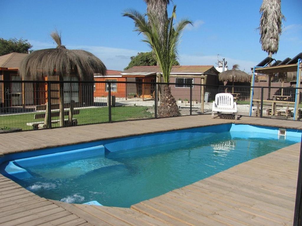 a swimming pool in a yard next to a house at Cabañas Don Gustavo in La Serena