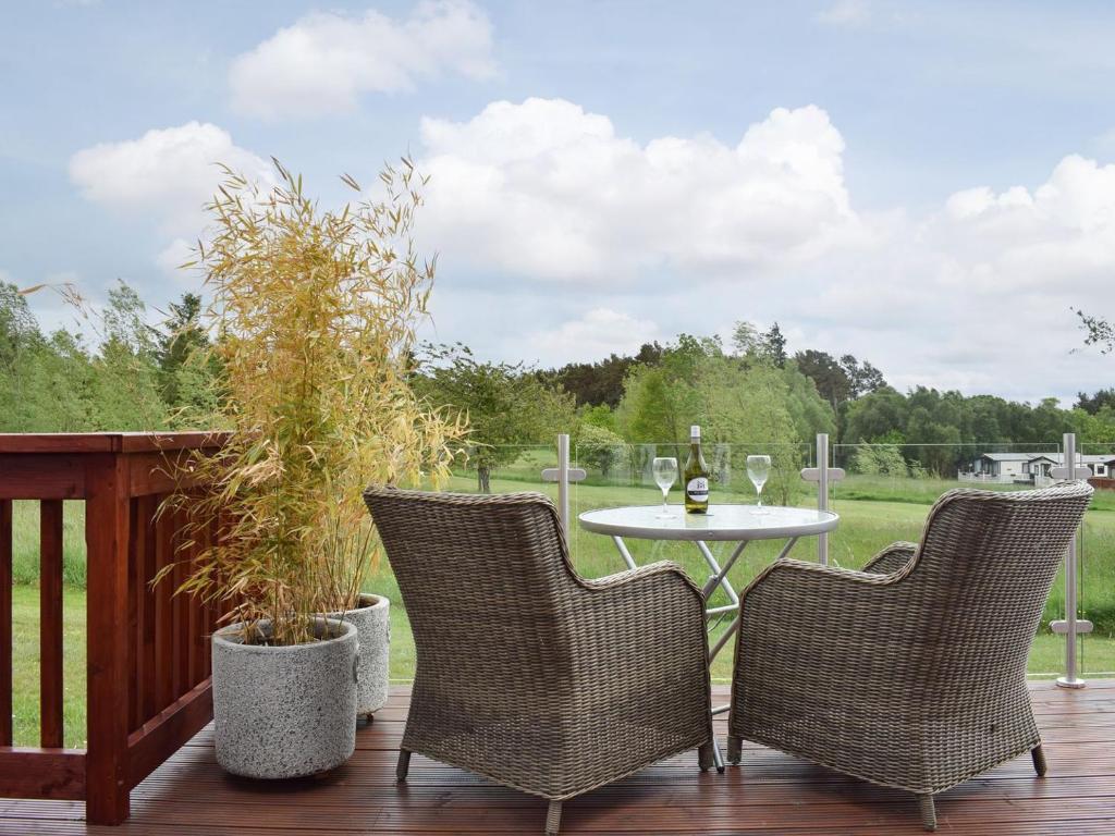 a patio with a table and chairs on a deck at Whinfell in Newton on the Moor