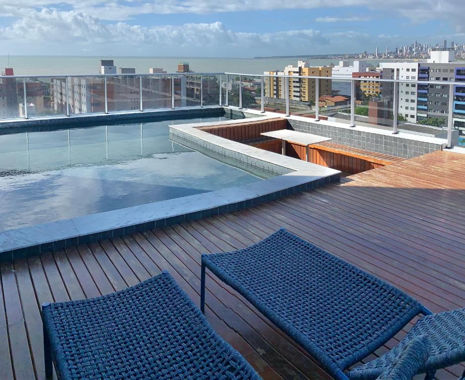a balcony with two blue benches on a roof at Villi 503C in João Pessoa