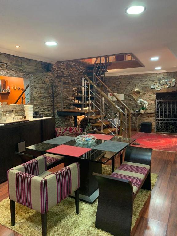 a dining room with a table and chairs and a staircase at Casa do Soto in Milhão