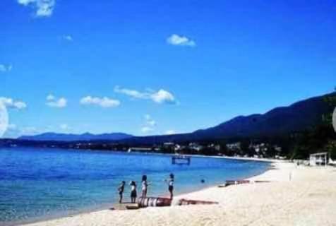 un grupo de personas de pie en una playa en 琵琶湖畔澄の宿 en Otsu