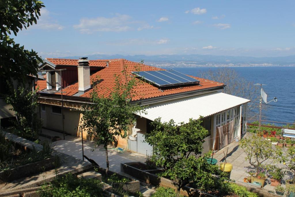 a house with solar panels on the roof at Double Room Medveja 7775c in Lovran