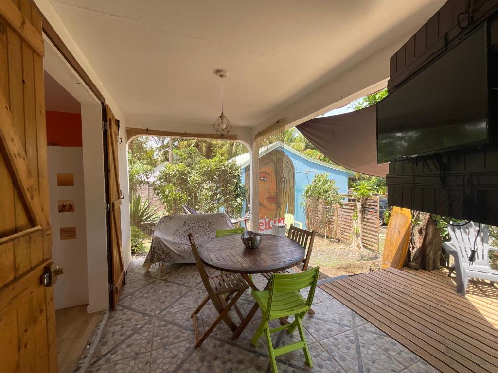 a patio with a table and chairs in a room at BUNGALOWS LES VAGUES ABONDES in Sainte-Anne