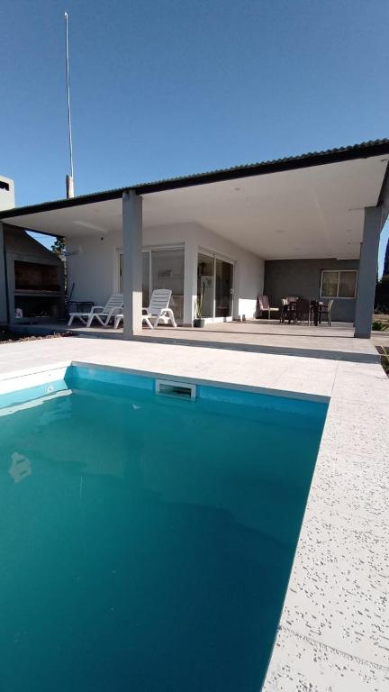 a blue swimming pool in front of a house at Los Colibries II in San Pedro