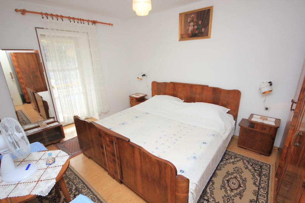 ein Schlafzimmer mit einem Holzbett in einem Zimmer in der Unterkunft Apartments by the sea Vis - 2477 in Vis