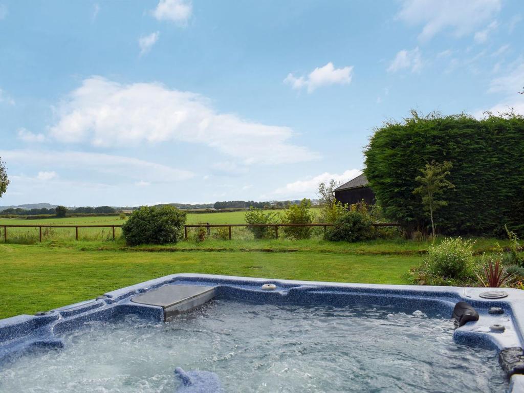 a swimming pool in a yard with a field at Grafton Farm in Loppington