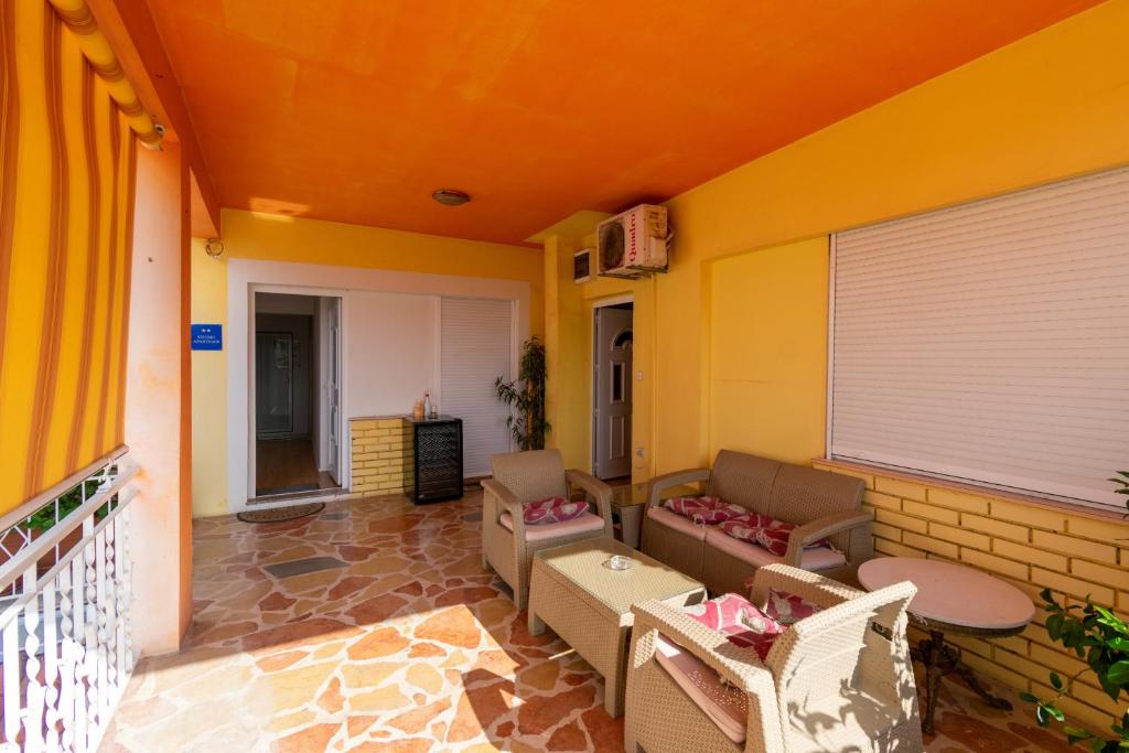 a patio with a couch and chairs on a balcony at Apartments with a parking space Bibinje, Zadar - 18275 in Bibinje