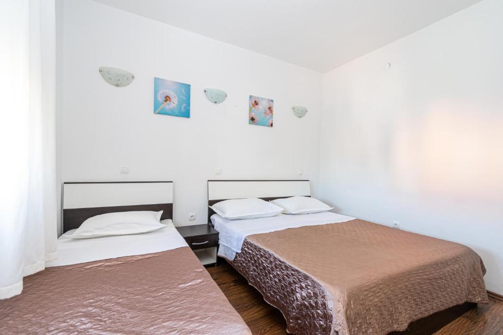 two beds in a room with white walls at Apartments with a parking space Bibinje, Zadar - 18275 in Bibinje