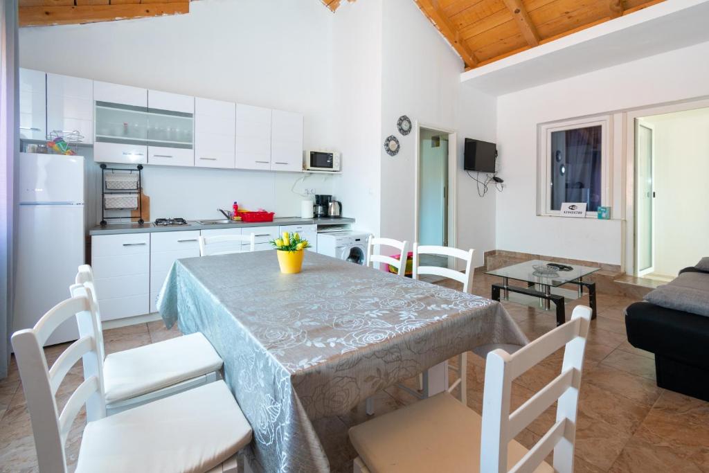 a kitchen and dining room with a table and chairs at Apartments with a parking space Bibinje, Zadar - 18275 in Bibinje