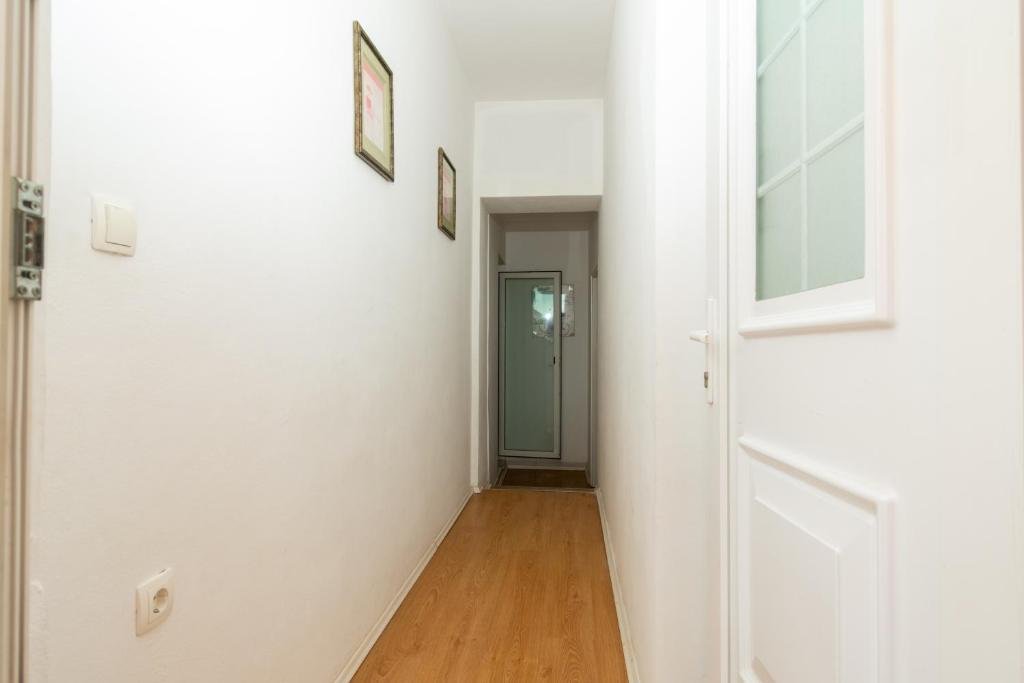 an empty hallway with a white door and a wooden floor at Apartments with a parking space Bibinje, Zadar - 18275 in Bibinje